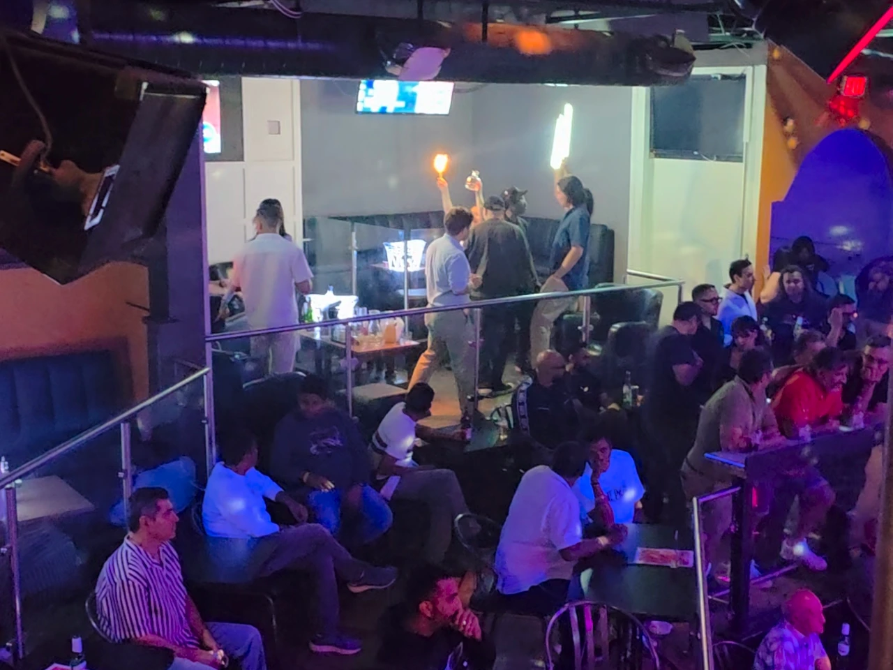 An elevated view across the illuminated Whiskey club and its guests